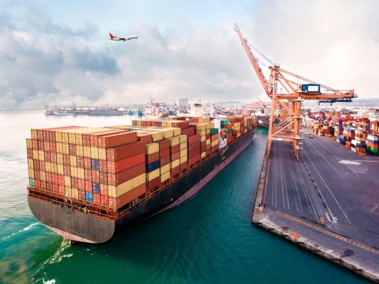 Airplane flying over international port.